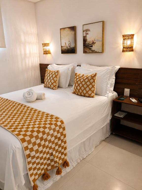 a bedroom with a bed with a checkered blanket on it at Pousada Galemares in Maragogi