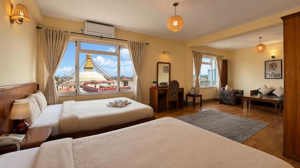a hotel room with two beds and a large window at Hotel Sherwi Hyul in Kathmandu