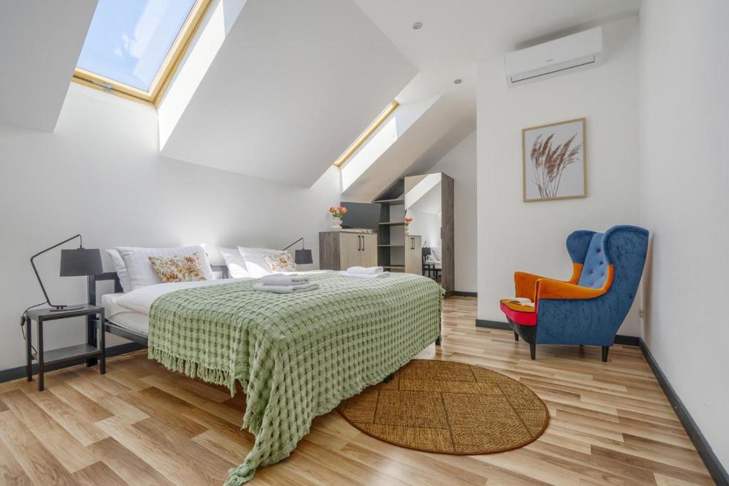 a bedroom with a bed and a couch and a chair at MŁYŃSKA 8 Opole-Górki in Opole