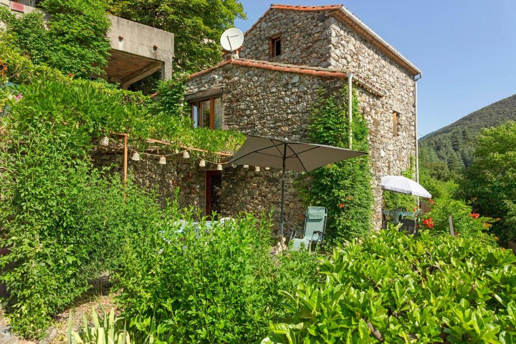 a building with an umbrella in front of it at La Clé de l'Arboux in Mandagout