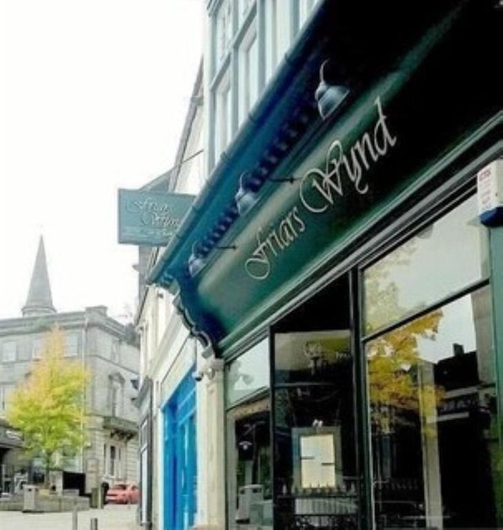 a store with a green awning on a city street at Friars Wynd Guest Rooms in Stirling