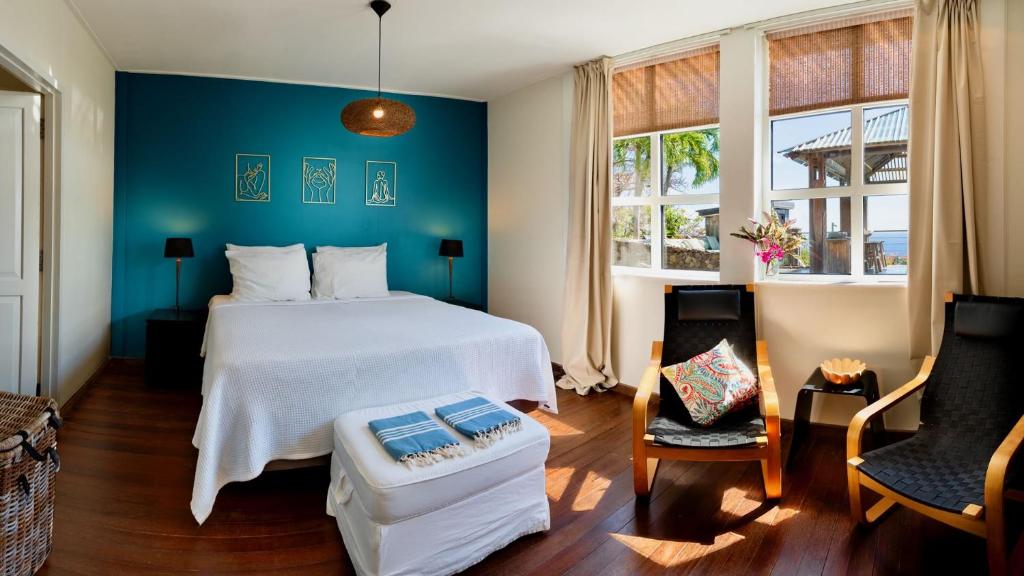 a bedroom with a white bed and a blue wall at Whale Tails Island Suites & Villas in Oranjestad