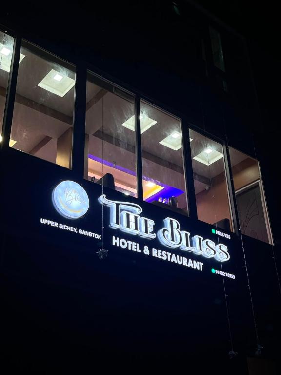 a building with a sign for the bliss hotel and restaurant at The Bliss Hotel and Restaurant in Gangtok