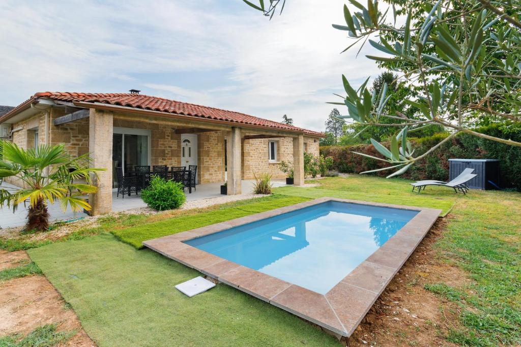 a house with a swimming pool in the yard at Maison du Périgord in Pazayac