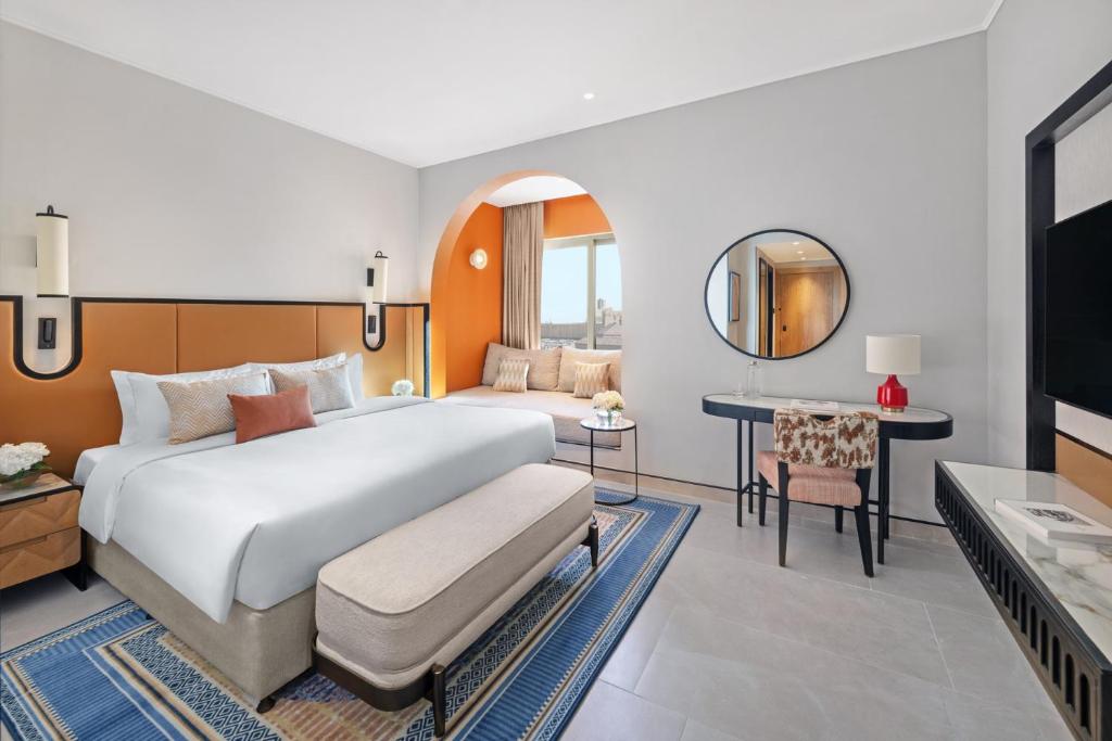a bedroom with a large bed and a mirror at Oaks Ibn Battuta Gate Dubai in Dubai