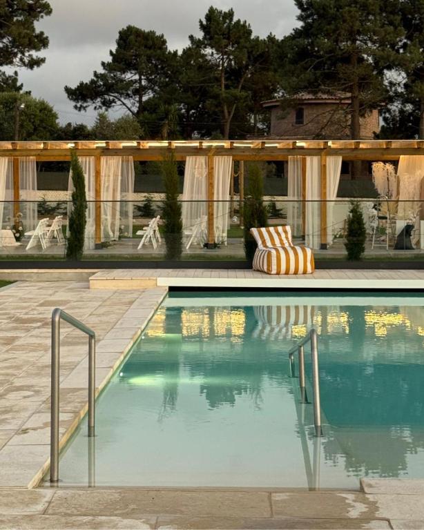 a swimming pool next to a house with a tent at MJ Guest House in Póvoa de Varzim