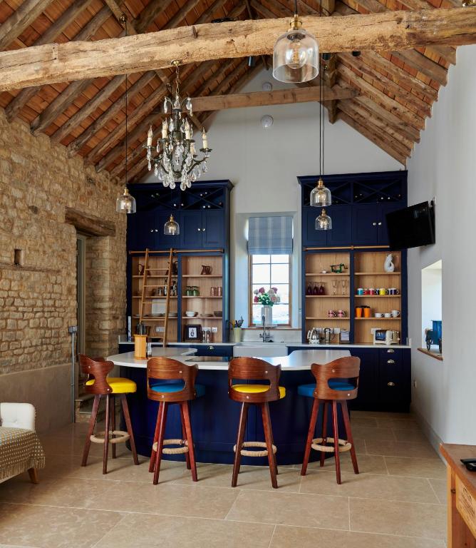 a kitchen with blue cabinets and bar stools at The Studio in Castle Bytham