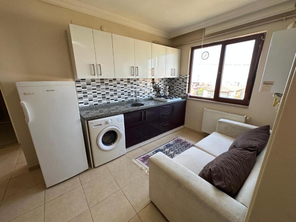 a kitchen with a couch and a washer and dryer at ST Apart in Pelitli