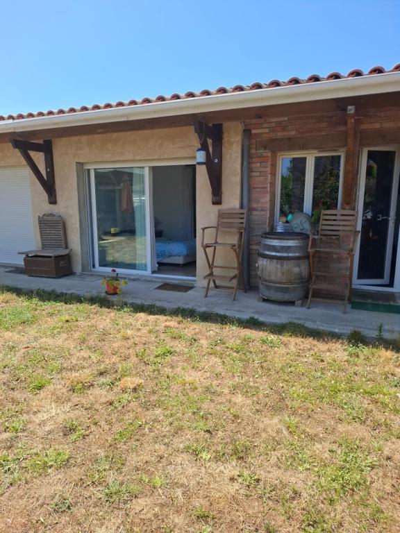 a patio with a barrel and chairs on a house at Chambre in Lesparre-Médoc