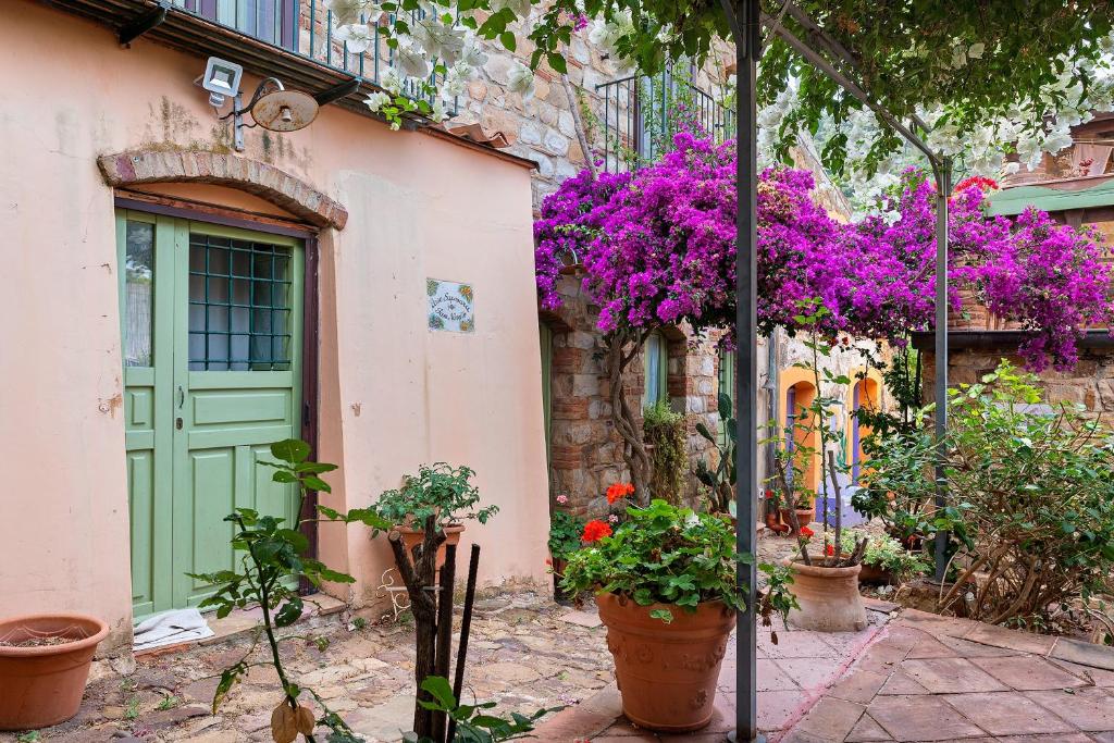 a building with a green door and some flowers at Case Saponara in Cefalù