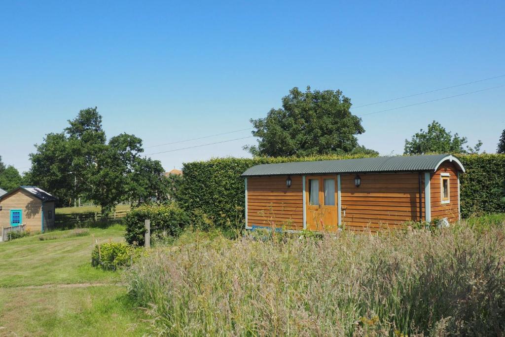 a wooden cabin in the middle of a field at Teasel Shepherd's Hut in Berwick-Upon-Tweed