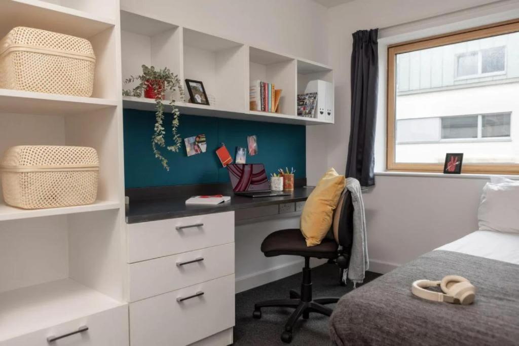 a bedroom with a desk and a bed and a window at Fitzroy Court near Luton Airport in Luton