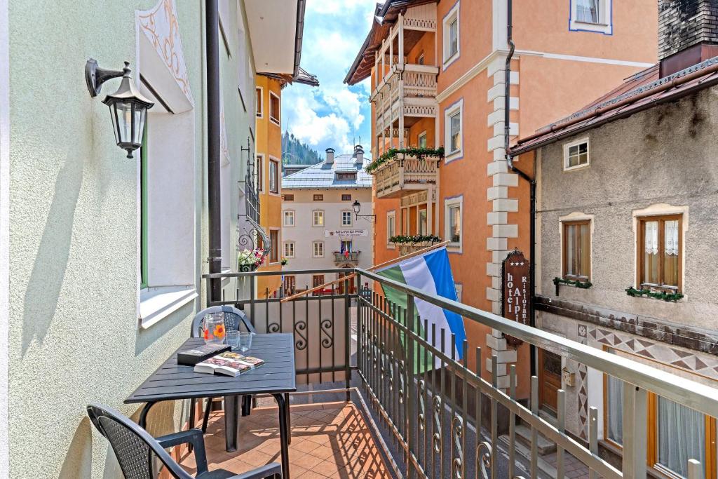 a balcony with a table and a view of a city at Appartamenti Boé 1 in Livinallongo del Col di Lana
