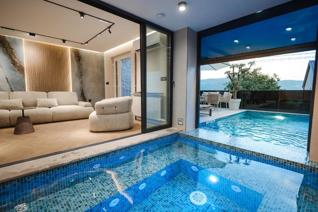 a house with a swimming pool and a living room at Villa The One Mostar with Heated Pool & Jacuzzi in Mostar