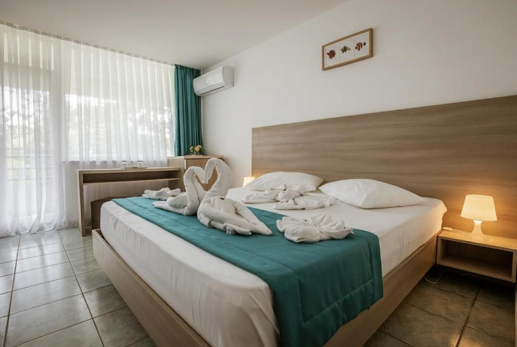 a hotel room with a bed with towels on it at Hotel Favorit in Venus