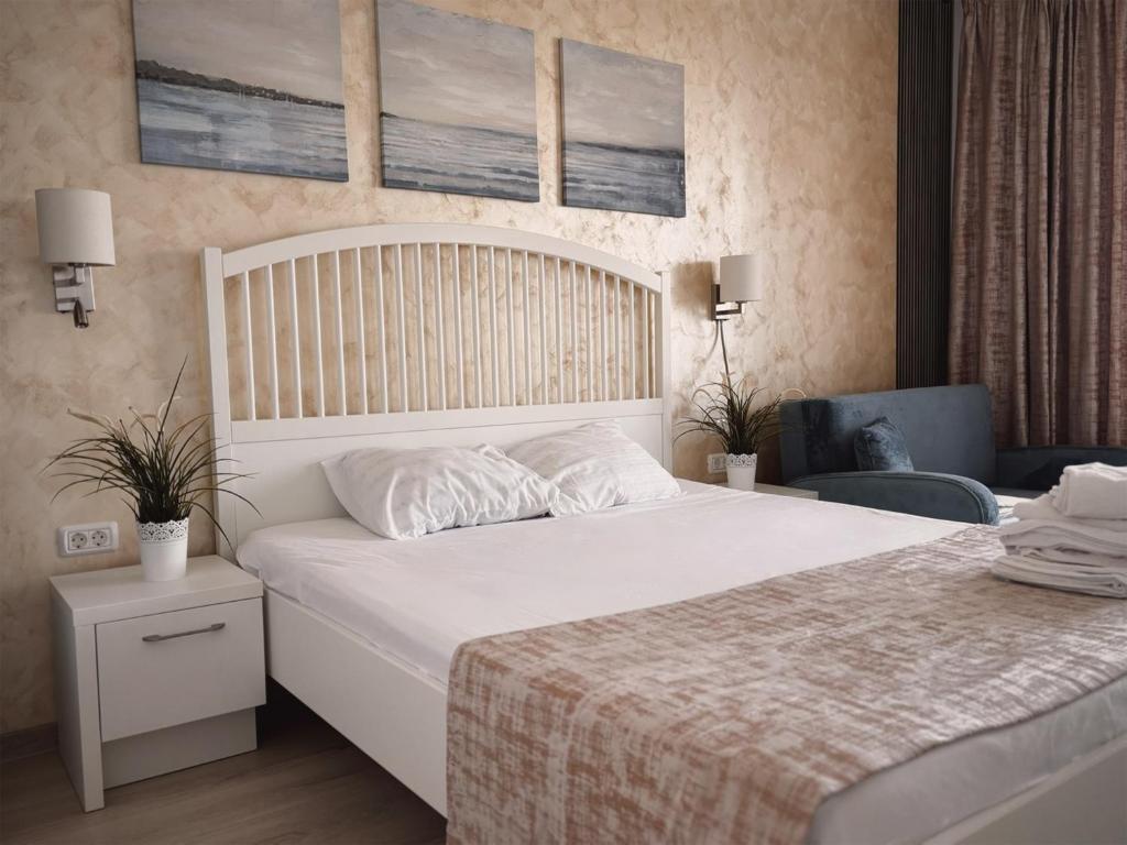 a bedroom with a large white bed and a chair at Studio Privat Reea Olimp in Olimp