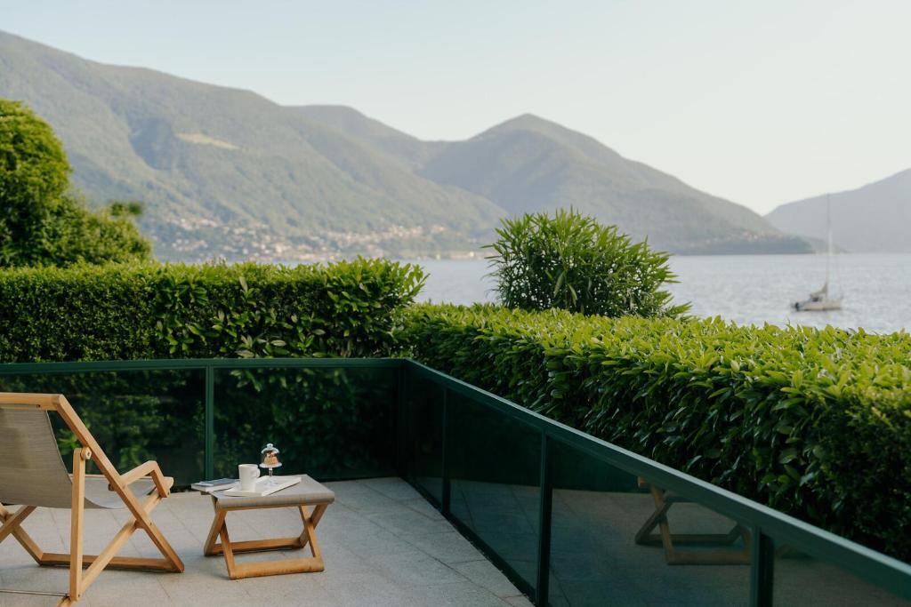a balcony with a table and chairs and the water at Hotel Eden Roc Marina in Ascona