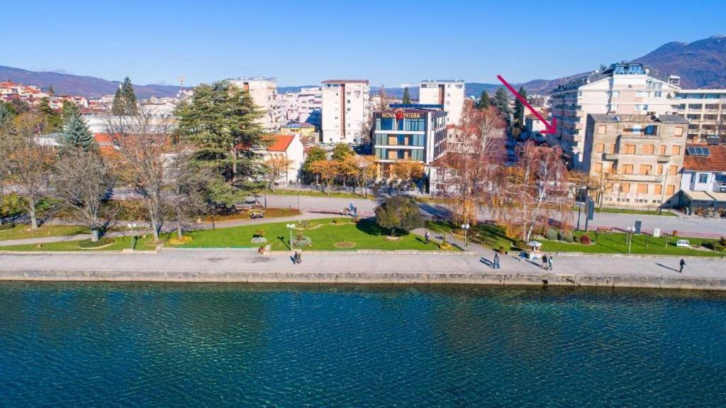 a park next to a body of water with buildings at Lake city in Ohrid