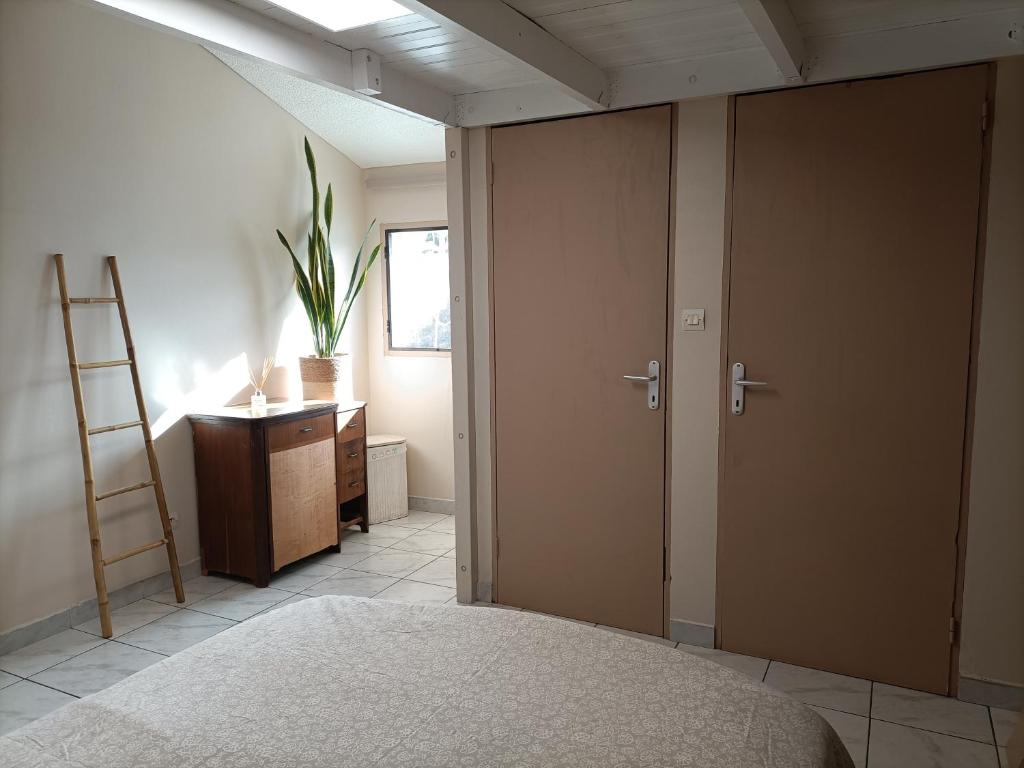 a bedroom with a bed and a ladder and a desk at Chambre cosy in Saint-Paul