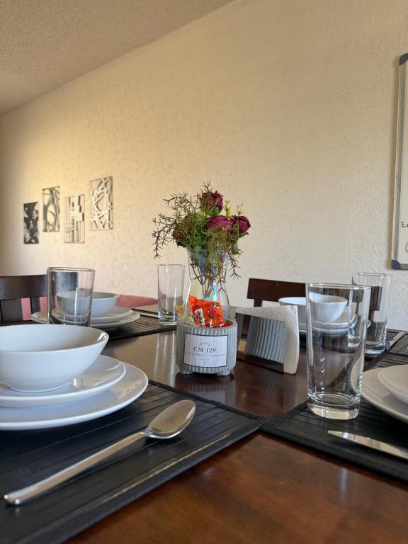 a wooden table with plates and glasses on it at Casa privada con estacionamiento in Hermosillo