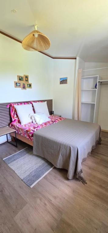 a bedroom with a large bed with a pink blanket at Escale Terre Rouge in Saint-André