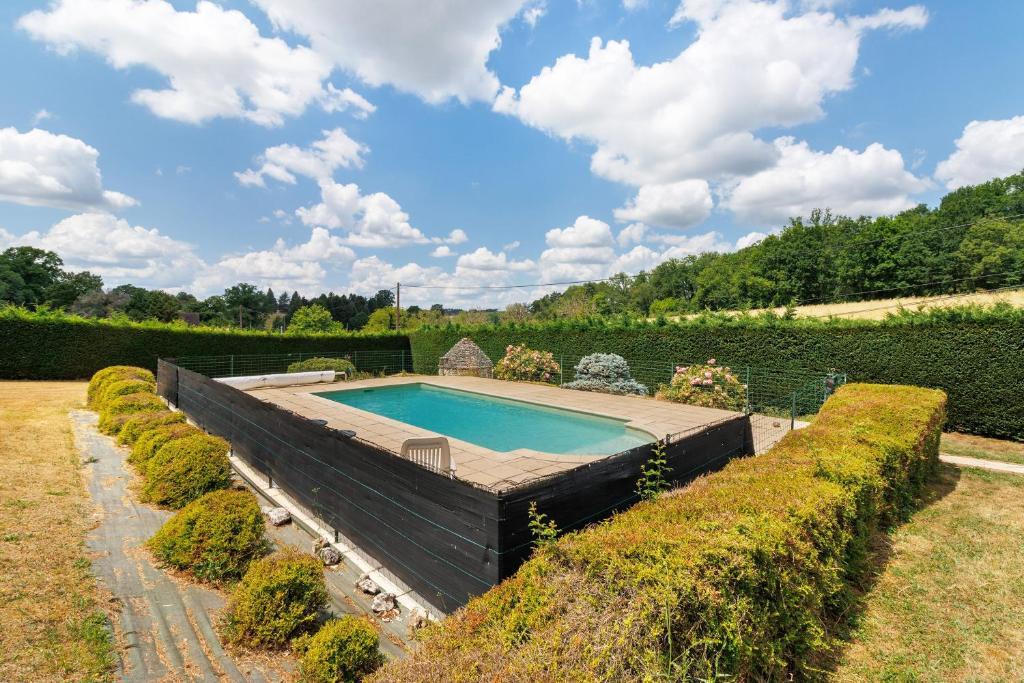 a swimming pool in the middle of a garden at Gite xl proche Grottes Lascaux in Fossemagne