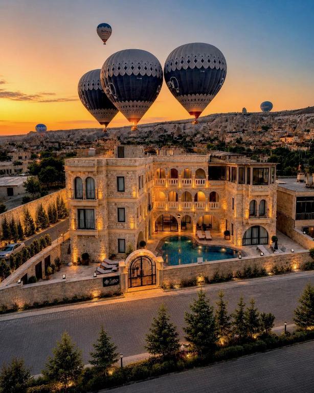 two hot air balloons flying over a mansion at Soho Cappadocia in Göreme