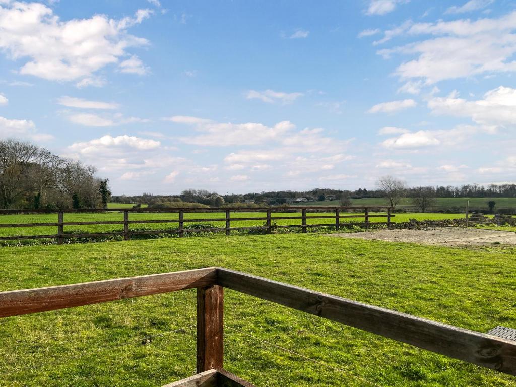 a wooden fence in a field with green grass at The Barn - Uk50912 in Wansford