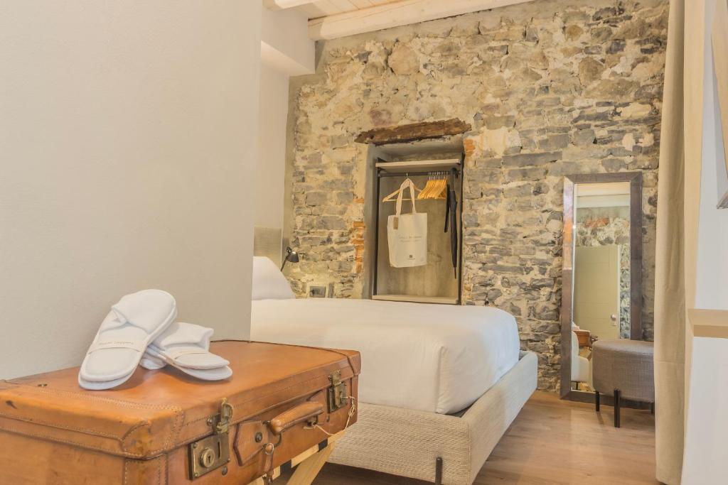 a bedroom with a bed and a stone wall at La Corte del Lario - Contrada Vecchia in Varenna