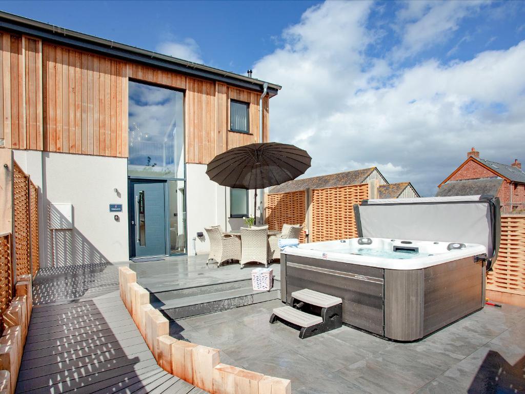 a hot tub on the deck of a house at Foxglove-Uk34612 in Nether Stowey