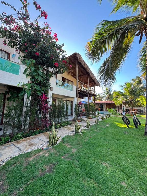 a house with a green yard next to a building at Casa Gili Moitas in Praia de Moitas