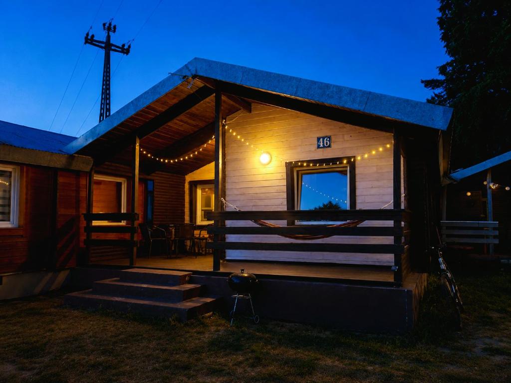 a small cabin with a porch at night at VerLema House 46 in Augustów
