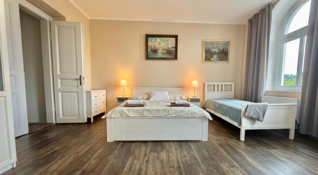 a bedroom with two beds and two windows at Apartmány Mary in Litoměřice