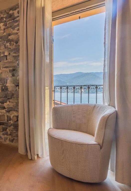 a chair in a room with a large window at La Corte Del Lario - Contrada Scoscesa in Varenna