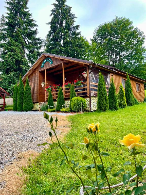 a log cabin with flowers in front of it at Mounty vendégház in Borzont