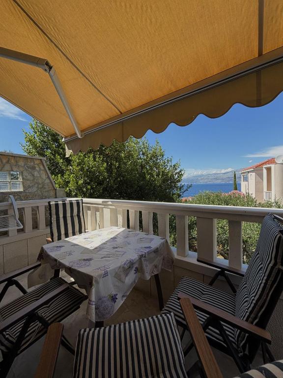 a table and chairs on a balcony with a view at Apartments Jela in Splitska