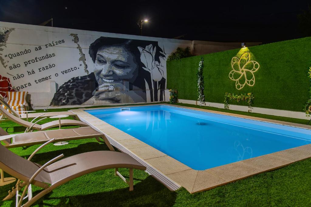 a swimming pool with two chairs and a mural at Casa da Lena in Batalha
