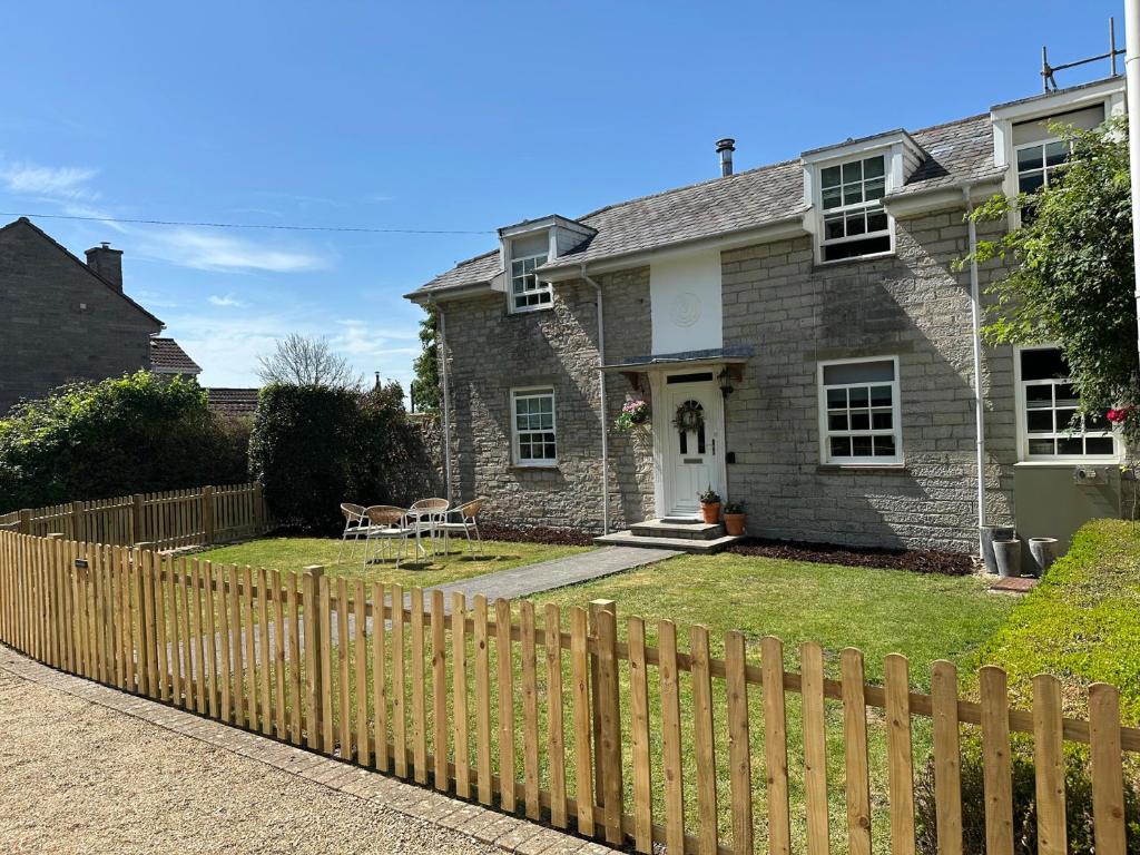 a house with a wooden fence in front of it at The Little Vicarage in Highbridge