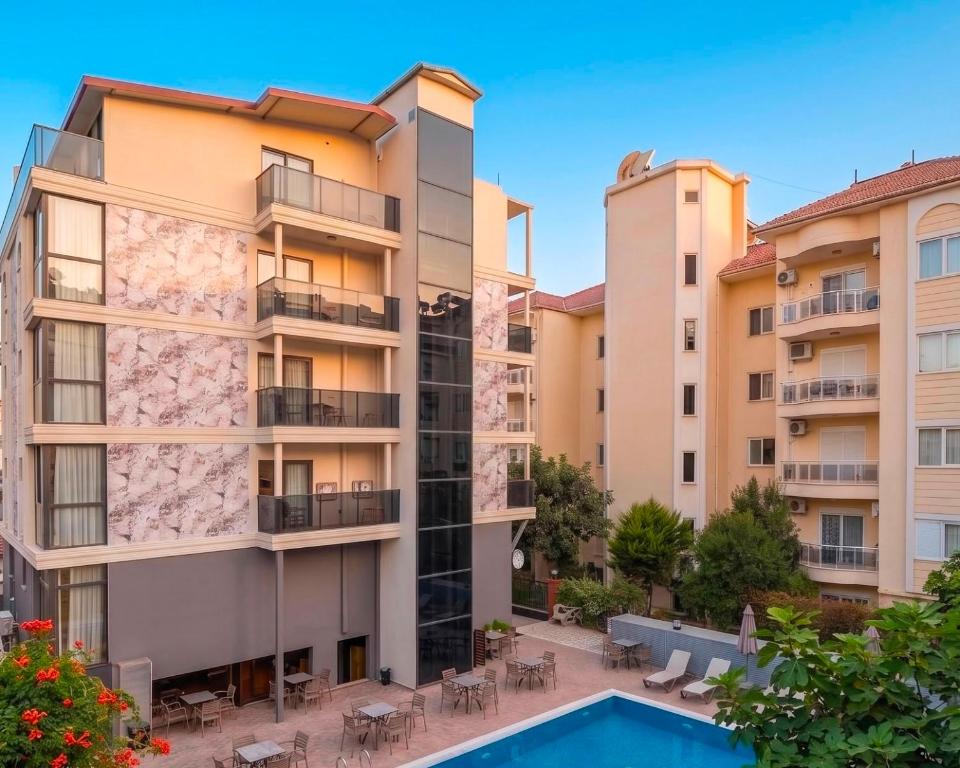 an apartment complex with a swimming pool and two buildings at Livane Beach Hotel in Alanya