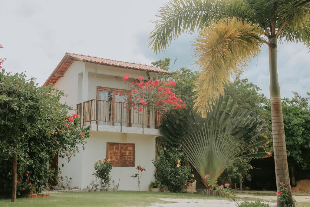 a house with a balcony and a palm tree at Vila hangloose Jericoacoara in Acaraú