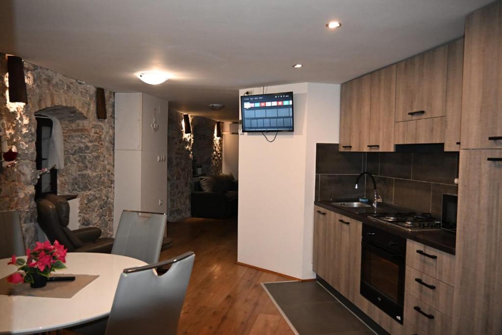a kitchen and dining room with a table and a television at Leona in Senj
