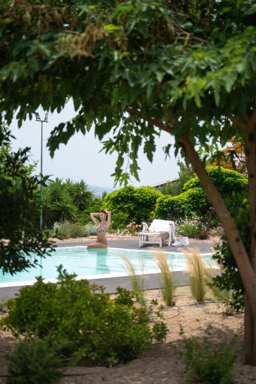 a woman in a bikini standing in a swimming pool at Sa Mola in Bonarcado