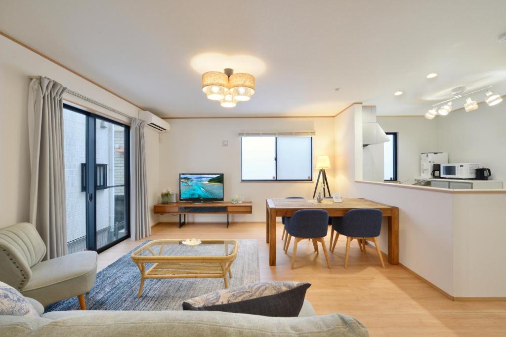 a living room with a table and a kitchen at 北谷町港1 in Chatan