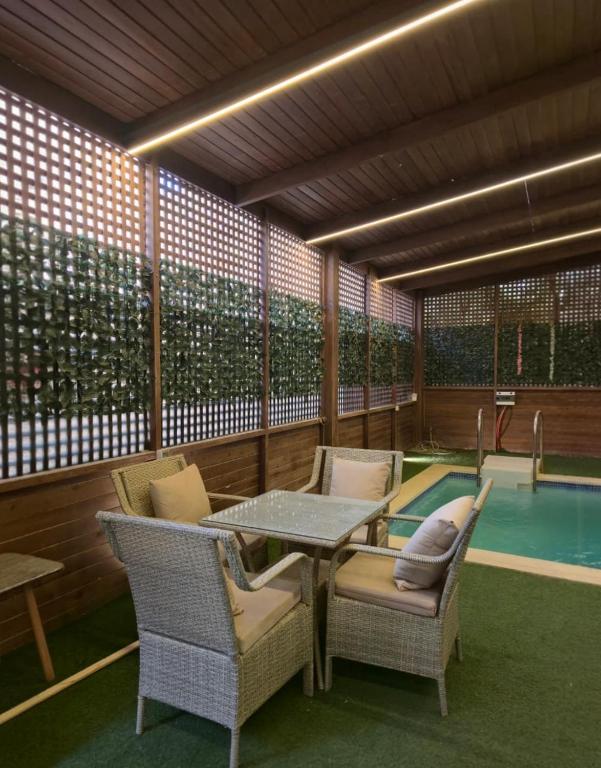 a patio with a table and chairs and a pool at كمبوند العالمية in Madinat Al Ashir min Ramadan