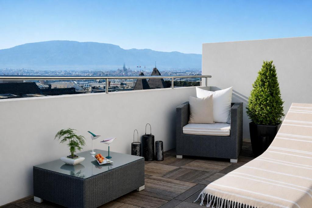 a balcony with a chair and a table on a roof at Auteuil Manotel in Geneva