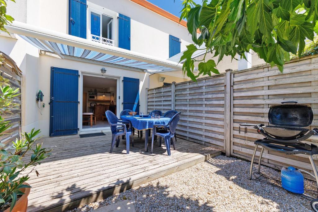 a patio with a table and chairs and a grill at Maison La Parée Plage in Bretignolles-sur-Mer