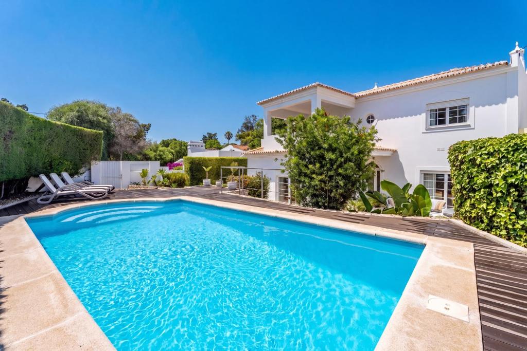 a swimming pool in front of a house at Casa Leonor, stunning 3 bedroom villa in Carvoeiro in Praia do Carvoeiro