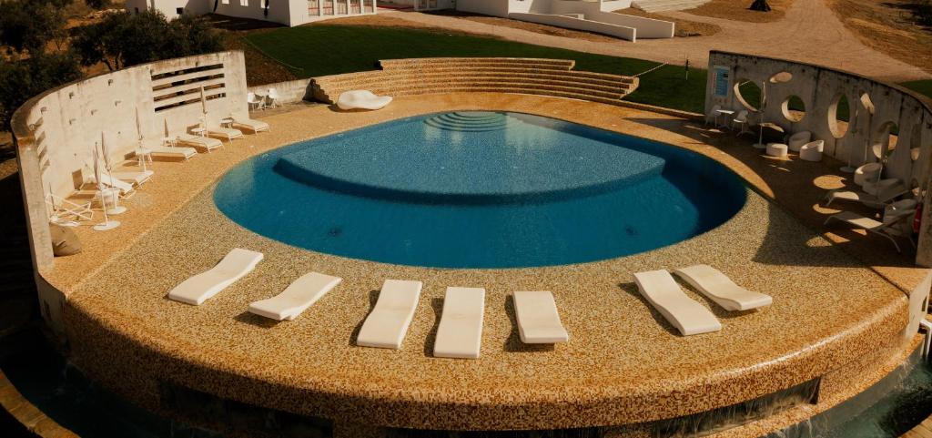 an overhead view of a swimming pool with lounge chairs and a pool at Herdade do Burrazeiro Turismo Rural no Alentejo in Borba