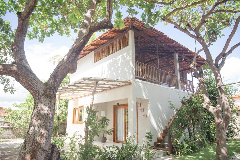 a white house with a tree at Vila hangloose pôr do sol in Acaraú