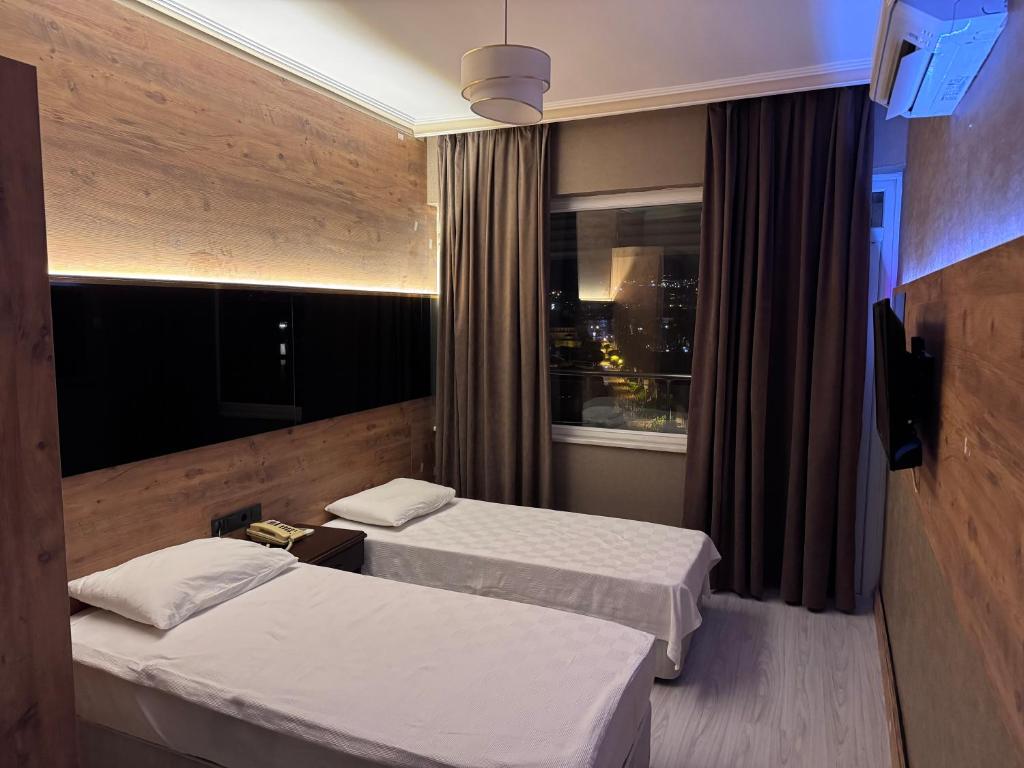 a hotel room with two beds and a window at Temiz Hotel in Alanya